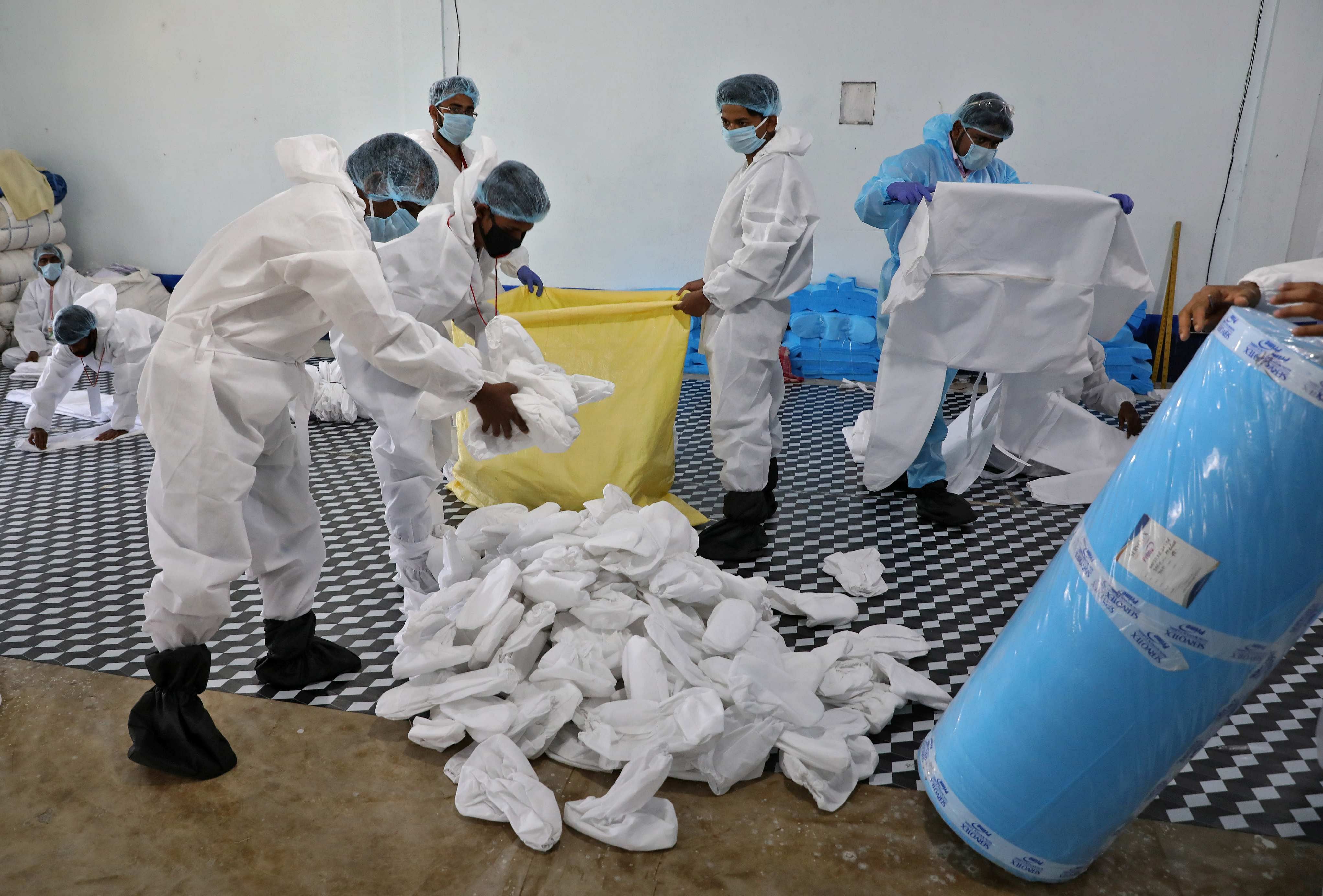 Workers pack protective suits at a workshop before supplying them to a government-run hospital during a 21-day nationwide lockdown. (Credit: Reuters)