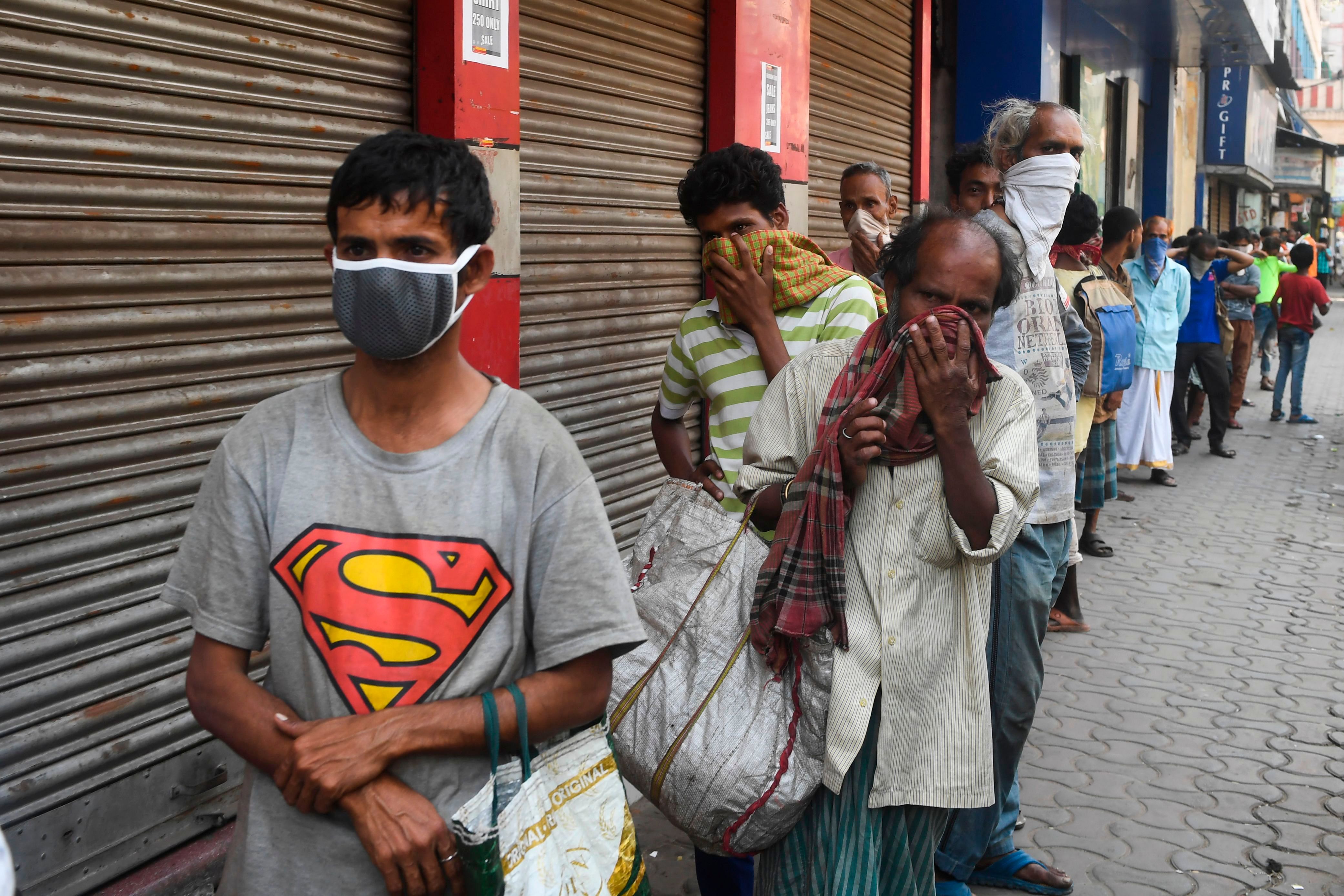 Day labourers and homeless people queue up to get free food during a government-imposed nationwide lockdown in Kolkata. (Credit: AFP)