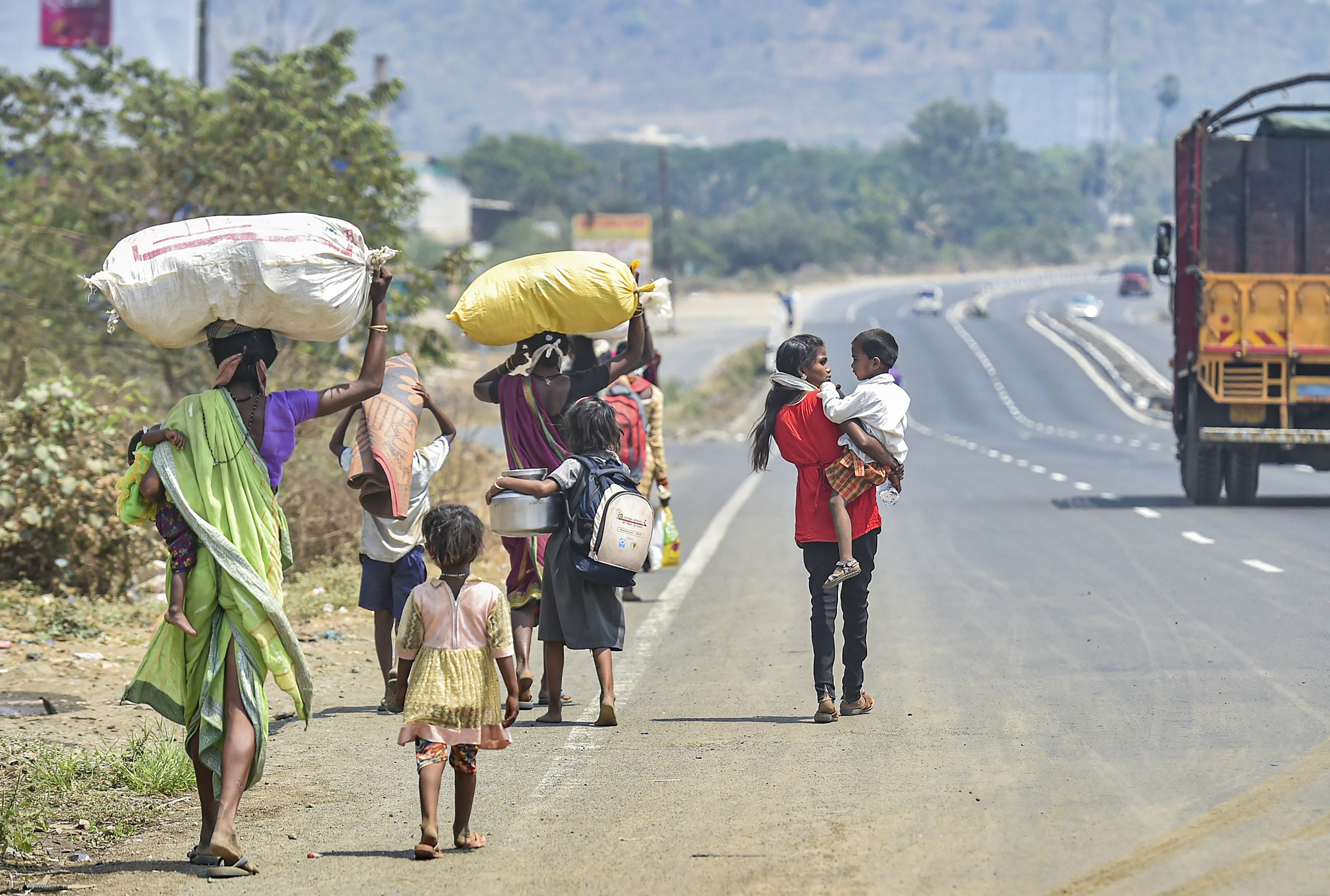 Migrants from Dahanu walk along the Mumbai-Ahmedabad highway, following the coronavirus lockdown. (PTI Photo)