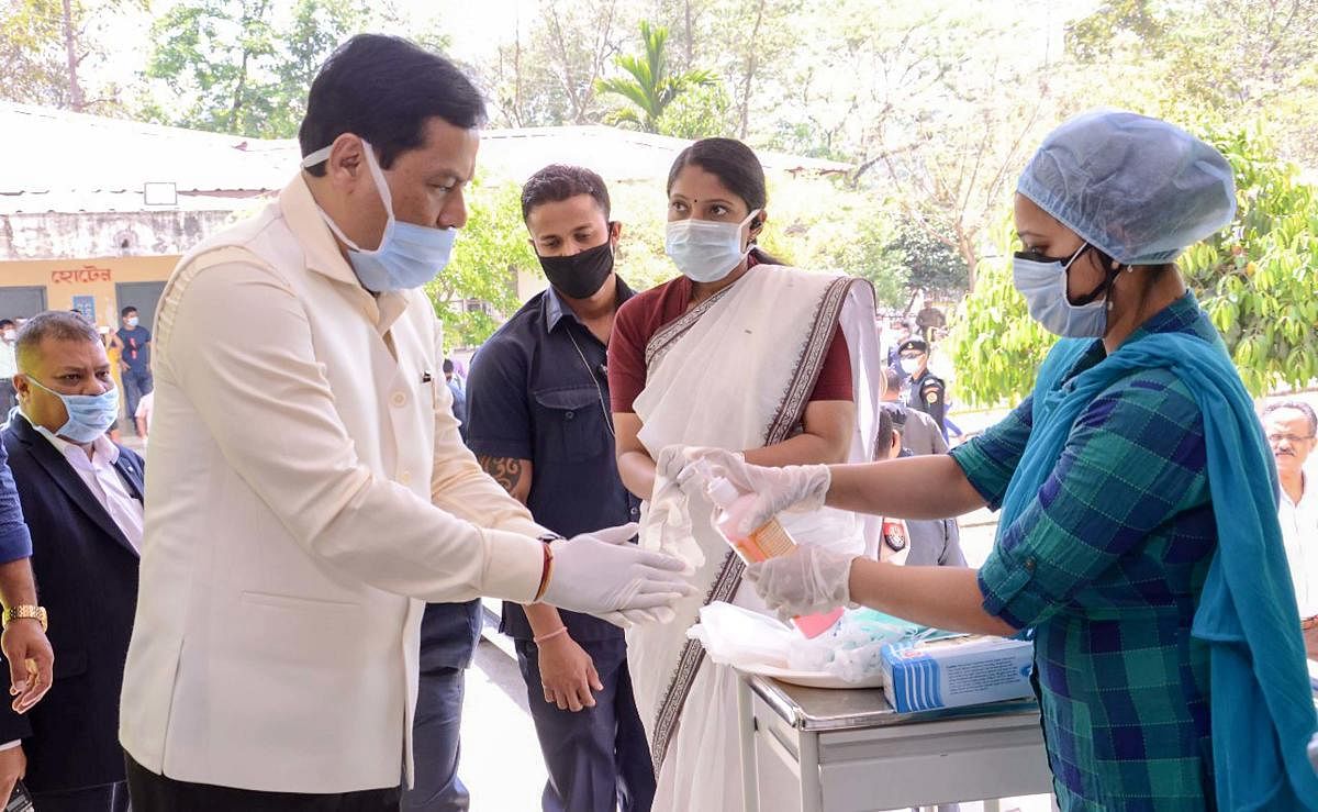 Assam Chief Minister Sarbananda Sonowal sanitizes his hands as he arrives at Bongaigaon Civil Hospital to review preparedness and to check preventive measures taken in wake of Coronavirus outbreak, in Chirang district. (PTI Photo)
