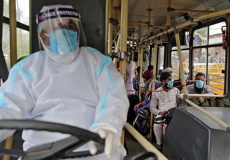 Men wearing protective masks sit inside a bus that will take them to a quarantine facility, amid concerns about the spread of coronavirus disease (COVID-19). (Reuters Photo)