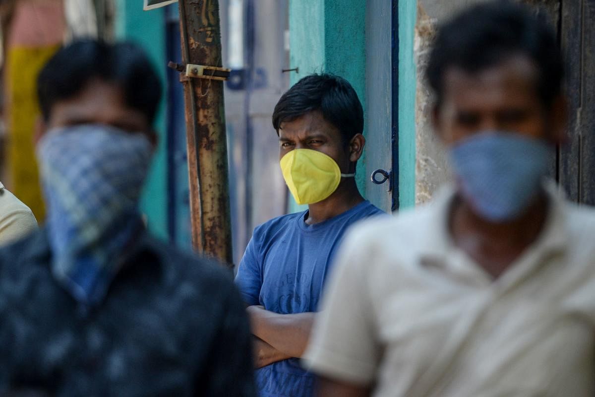 Migrant workers wait to receive food packets at an industrial area during a government-imposed nationwide lockdown as a preventive measure against the COVID-19 coronavirus, in Chennai on April 1, 2020. (Photo by Arun SANKAR / AFP)