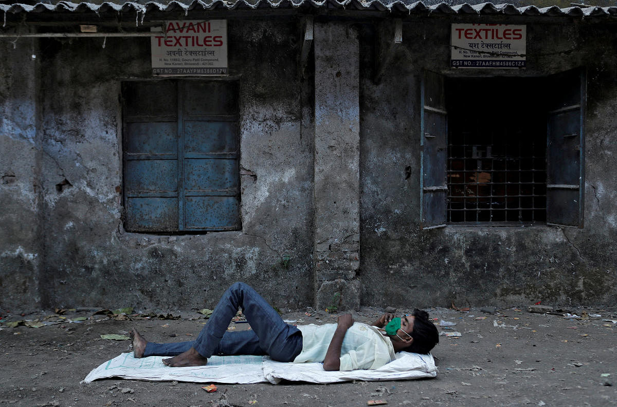 A migrant worker, who works in textile looms, speaks on his phone outside a loom after it was shut due to the 21-day nationwide lockdown to slow the spread of the coronavirus disease, in Bhiwandi on the outskirts of Mumbai, India, April 1, 2020. Credit: Reuters Photo