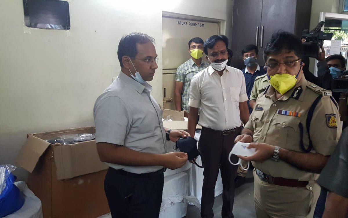 City Police Commissioner Bhaskar Rao examines confiscated masks. In all, police have seized 15,000 counterfeit masks.