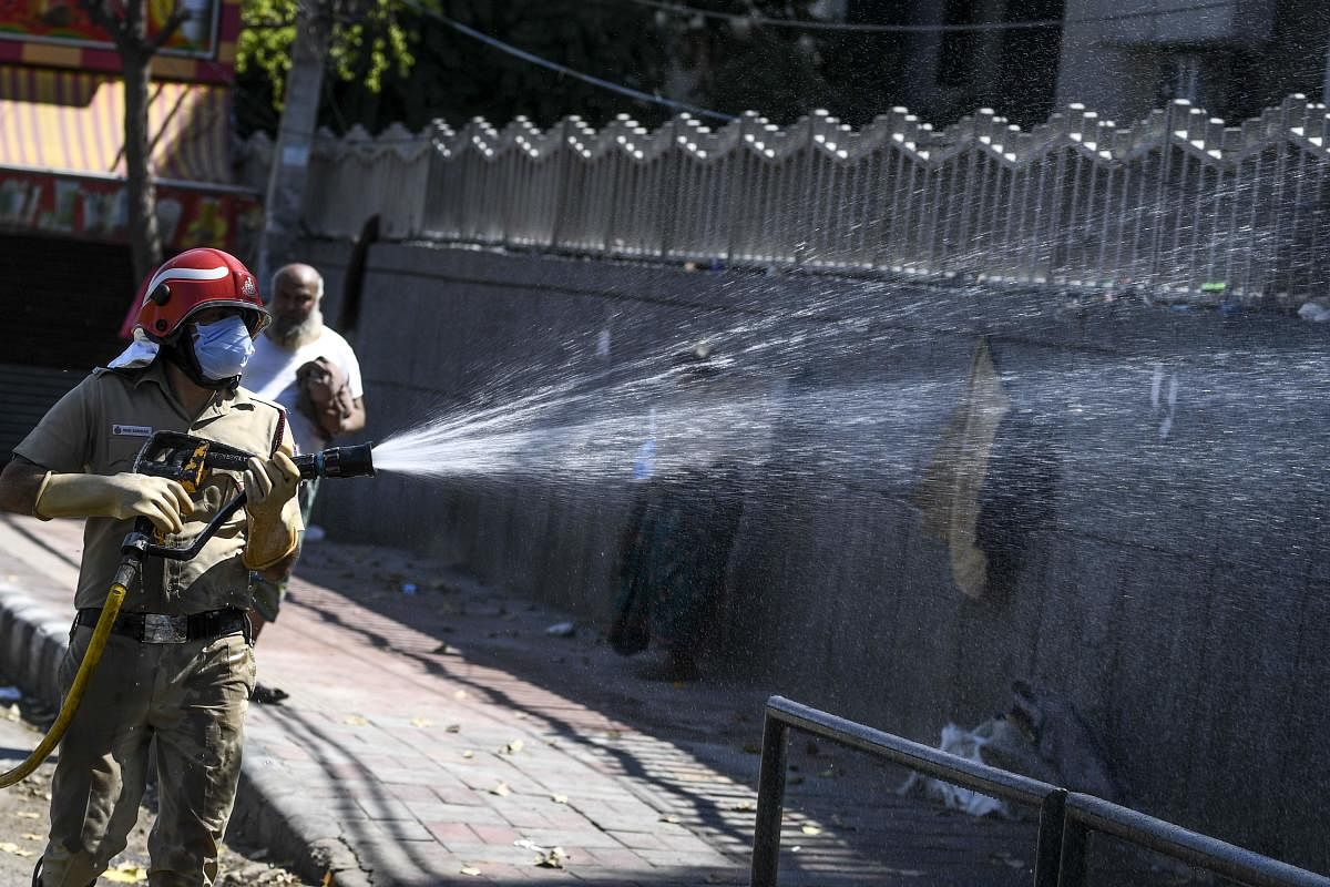 Delhi fire-fighters disinfect an area near Nizamuddin Markaz Mosque in New Delhi (AFP Photo)