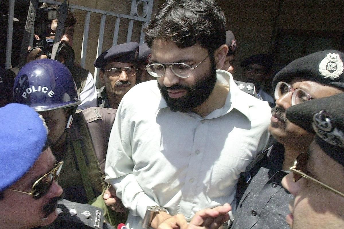 Pakistani police surround handcuffed Omar Sheikh as he comes out of a court in Karachi. AFP/File