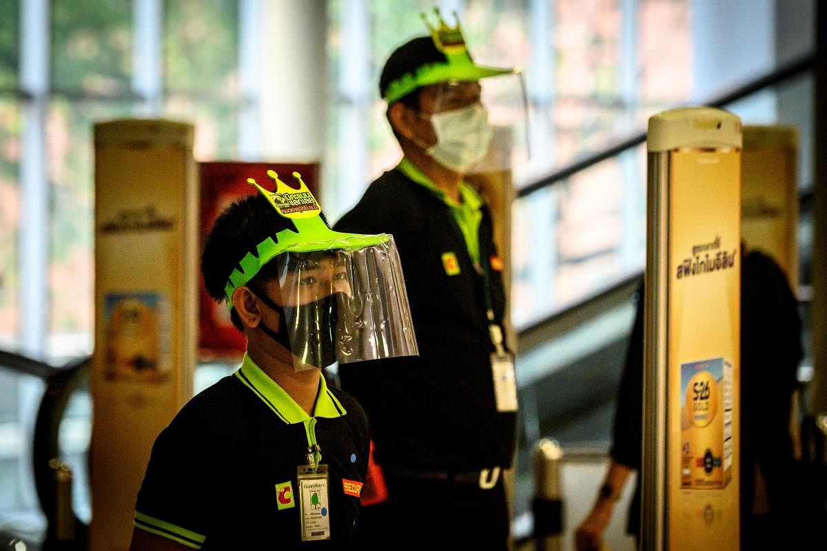 Supermarket employees in protective gear as a preventive measure against COVID-19 wait for customers in Bangkok. AFP