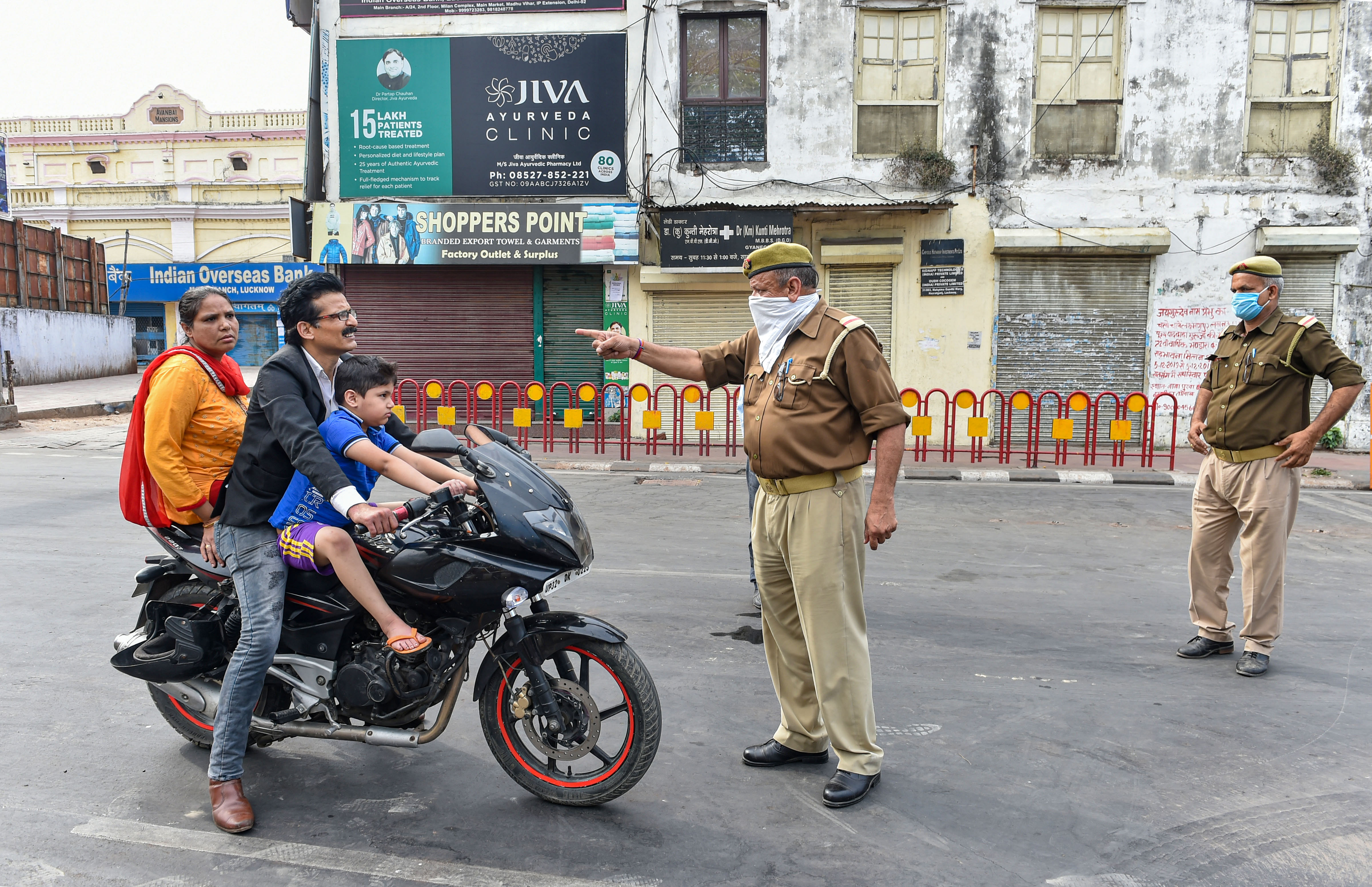 Lucknow: Police personnel stop commuters after the state government enforced lockdown in the city amid coronavirus pandemic. (Credit: PTI)