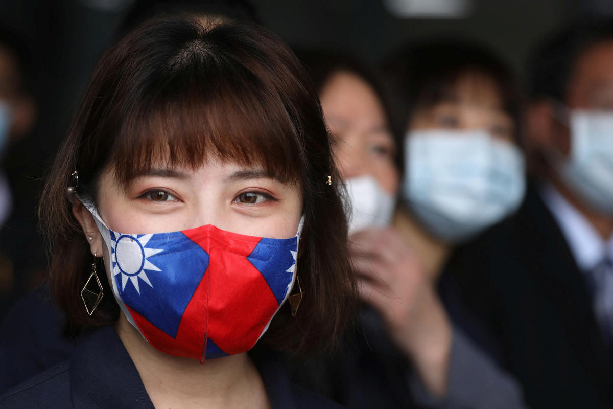 A staff wears a face mask with a Taiwanese flag design, as protection due to the coronavirus disease (COVID-19) outbreak, at a factory for non woven filter fabric used to make surgical face masks, in Taoyuan. Credit: Reuters Photo
