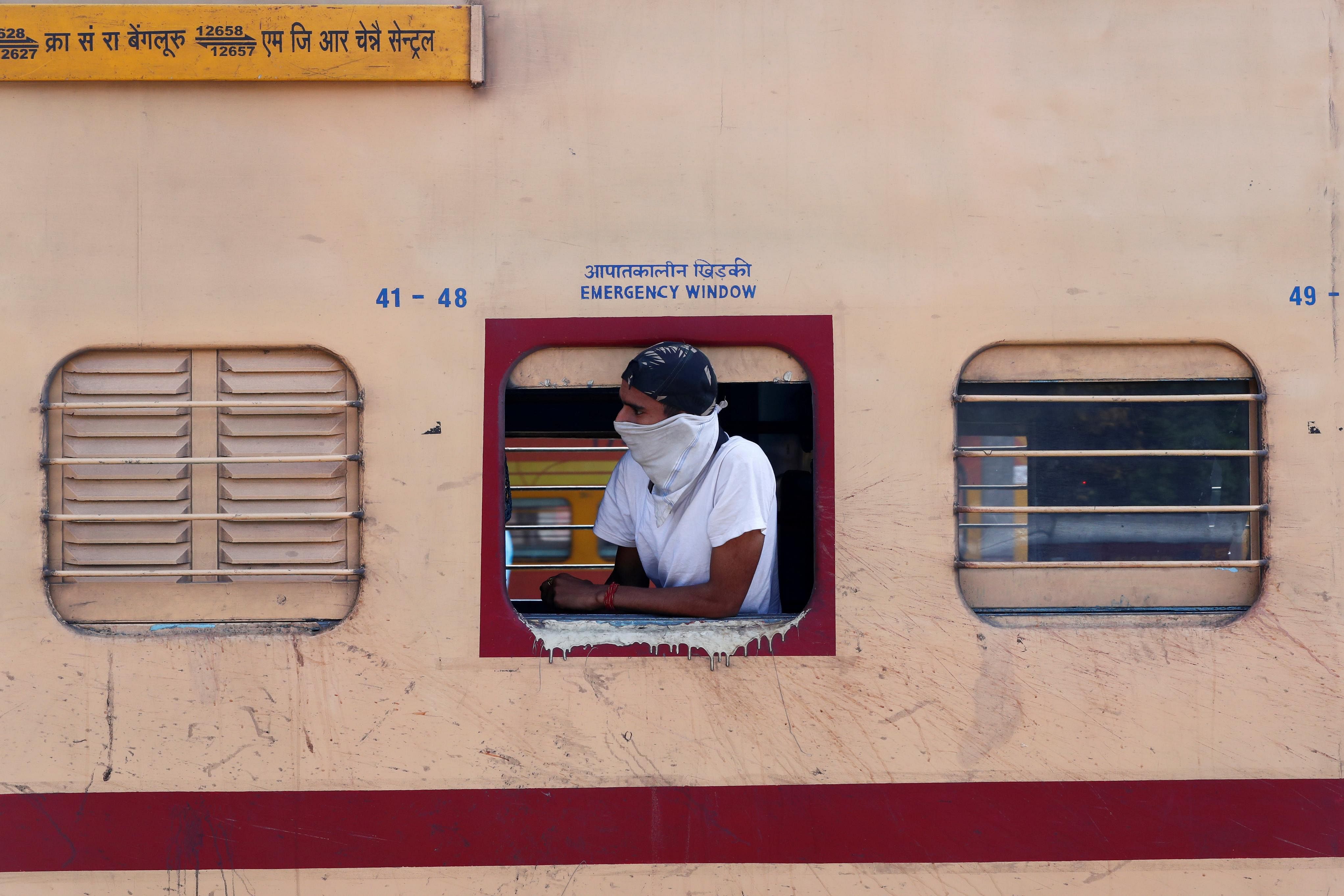 A man with his face covered looks out from a train during lockdown by the authorities to limit the spreading of coronavirus disease (COVID-19), in New Delhi. (Credit: Reuters)