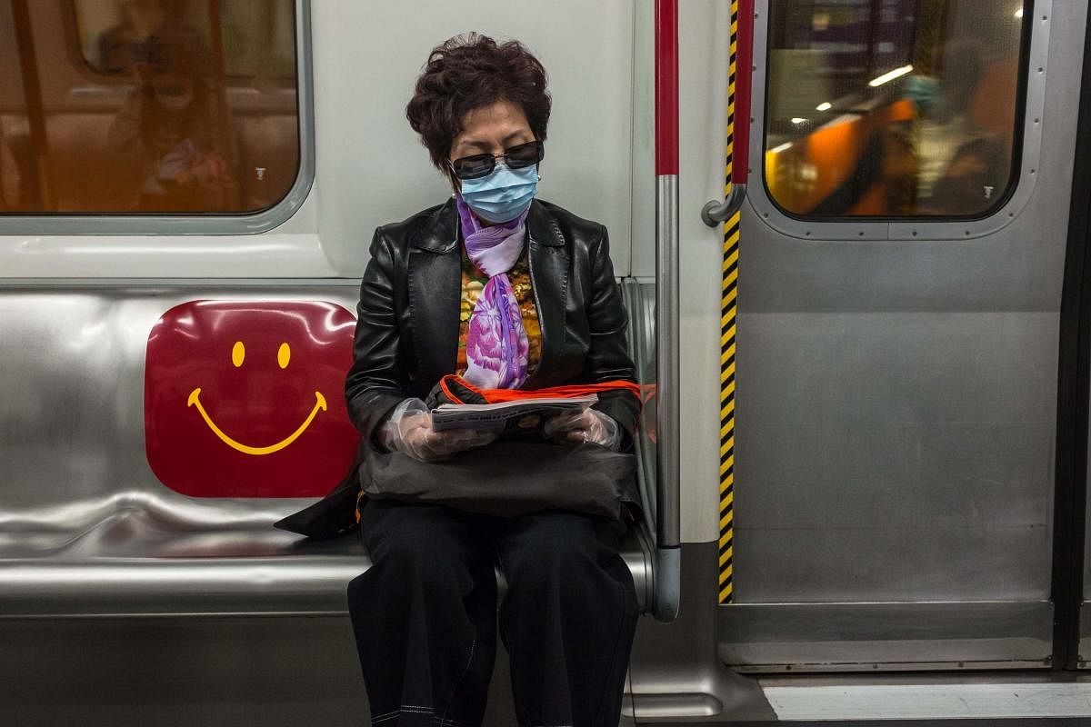 A woman wearing a face mask, amid concerns of the COVID-19 coronavirus, commutes on a train in Hong Kong on April 4, 2020. Credit: AFP Photo