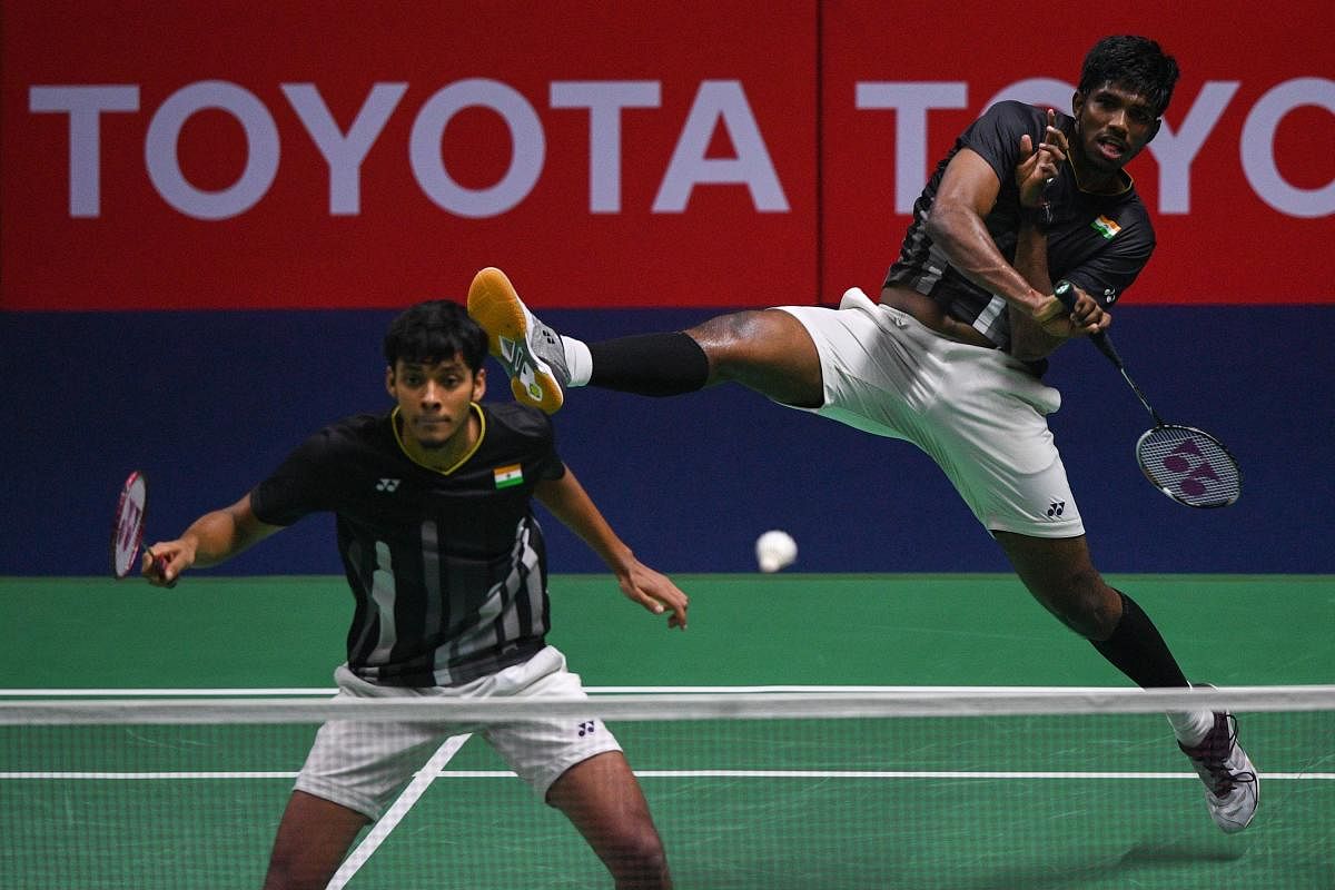 India's Satwiksairaj Rankireddy (R) hits a shot beside his partner Chirag Shetty against China's Li Jun Hui and Liu Yu Chen during their men's doubles final match at the Thailand Open badminton tournament in Bangkok on August 4, 2019. Credit: AFP Photo