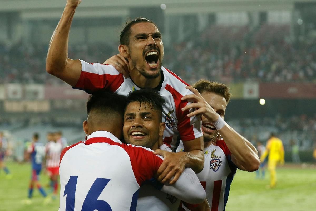 TK players mob Prabir Das (centre) after he set up David Williams (top) for the third goal against Bengaluru FC in the second leg of the Indian Super League semifinal in Kolkata.