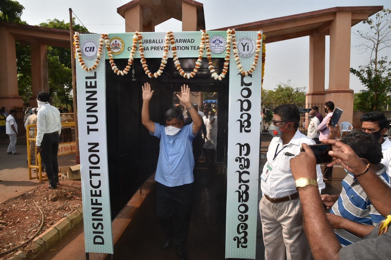 State Heavy and Medium Industries Minister Jagadish Shettar pass through the disinfection tunnel at Amargol Agriculture Produce market near Hubballi on Sunday. DH Photo
