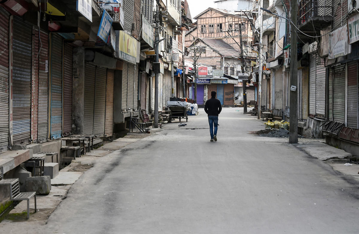 A man walks in a closed market during a nationwide lockdown to contain the spread of novel coronavirus, in Srinagar, Saturday, April 4, 2020. Credit: PTI Photo