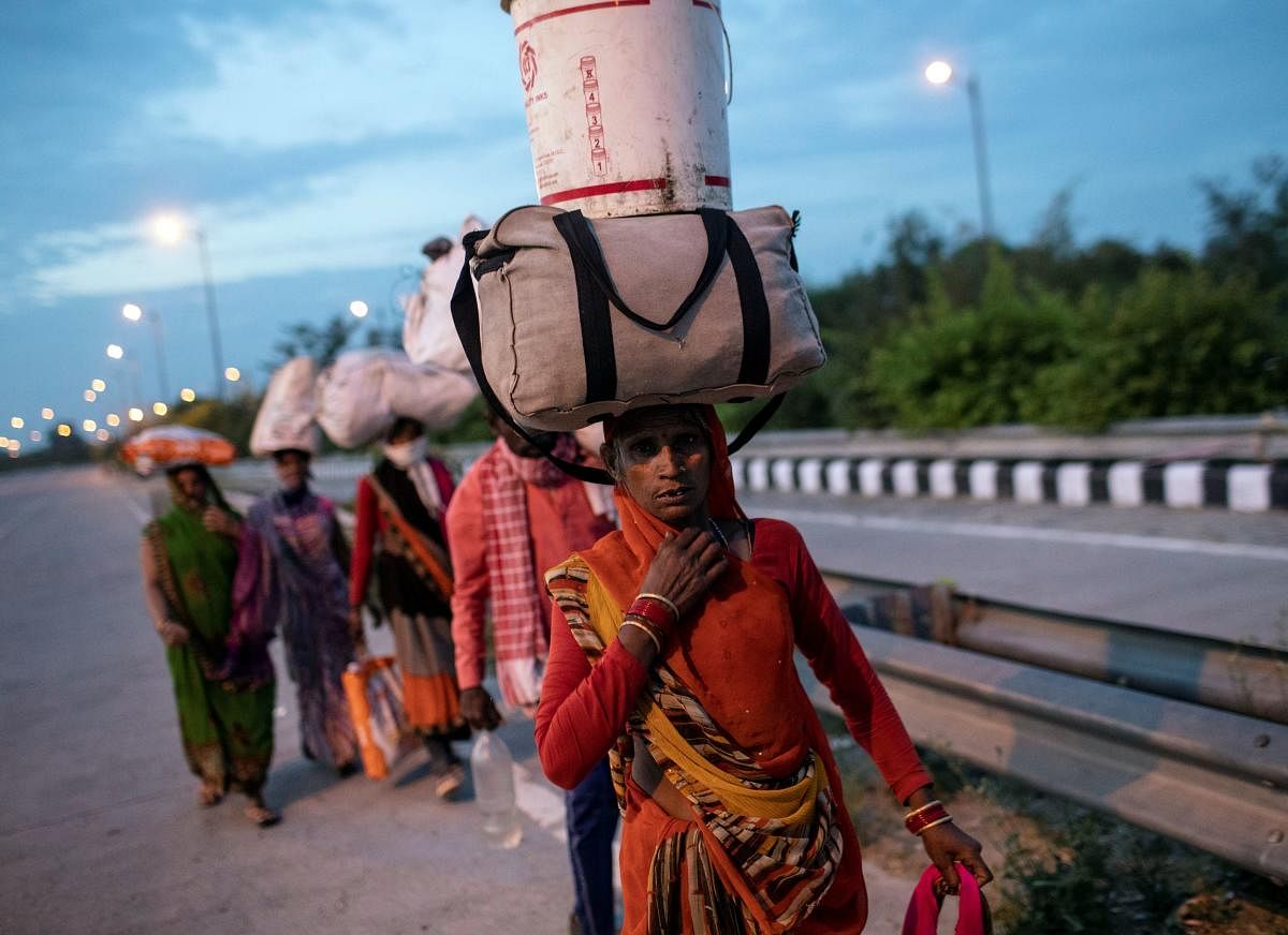 Migrant workers carry their belongings as they walk along a road to return to their villages, during a 21-day nationwide lockdown to limit the spreading of coronavirus disease, in New Delhi. Credit: Reuters Photo