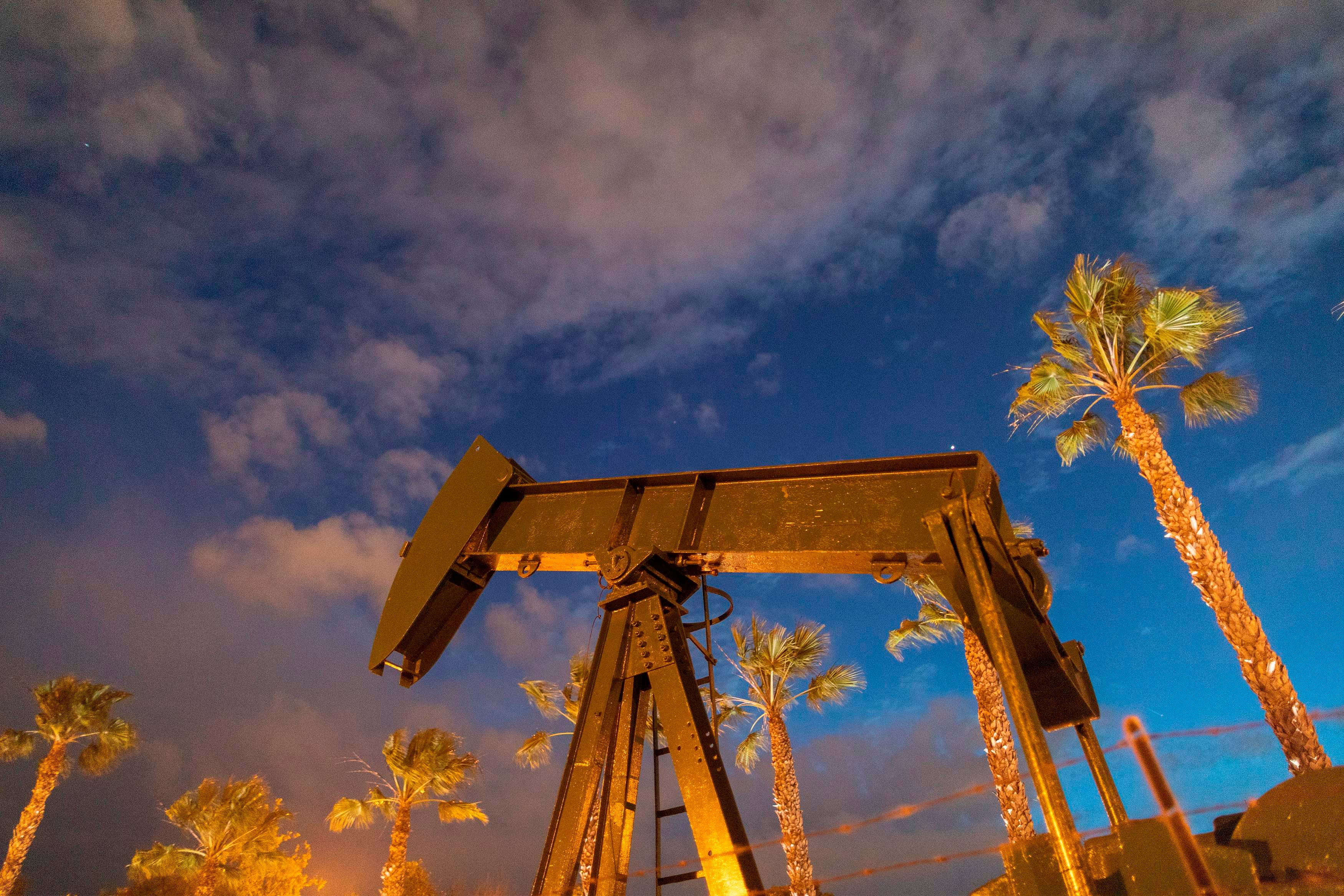 Pump jacks draw crude oil from the Long Beach Oil Field under Discovery Well Park in Signal Hill, California. (Credit: AFP)