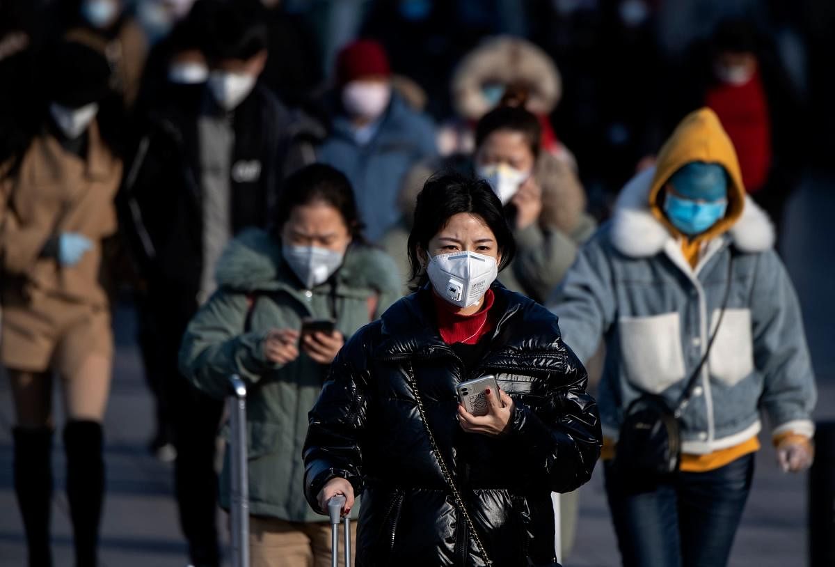 Travellers wearing facemasks arrive from various provinces at the Beijing Railway Station on February 3, 2020. AFP