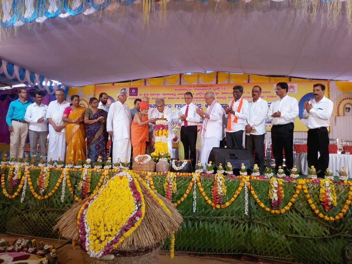 Pejawar Mutt pontiff Vishwesha Teertha Swami and Dharmasthala Dharmadhikari D Veerendra Heggade jointly inaugurate the valedictory of the solar village project at Amasebailu in Udupi district on Sunday.