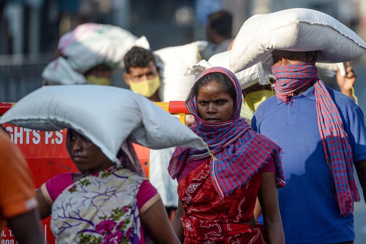 Migrant workers carrying sacks of groceries distributed at their workplace walk on a street during a government-imposed nationwide lockdown as a preventive measure against the COVID-19 coronavirus, in Chennai on April 4, 2020. Credit: AFP Photo