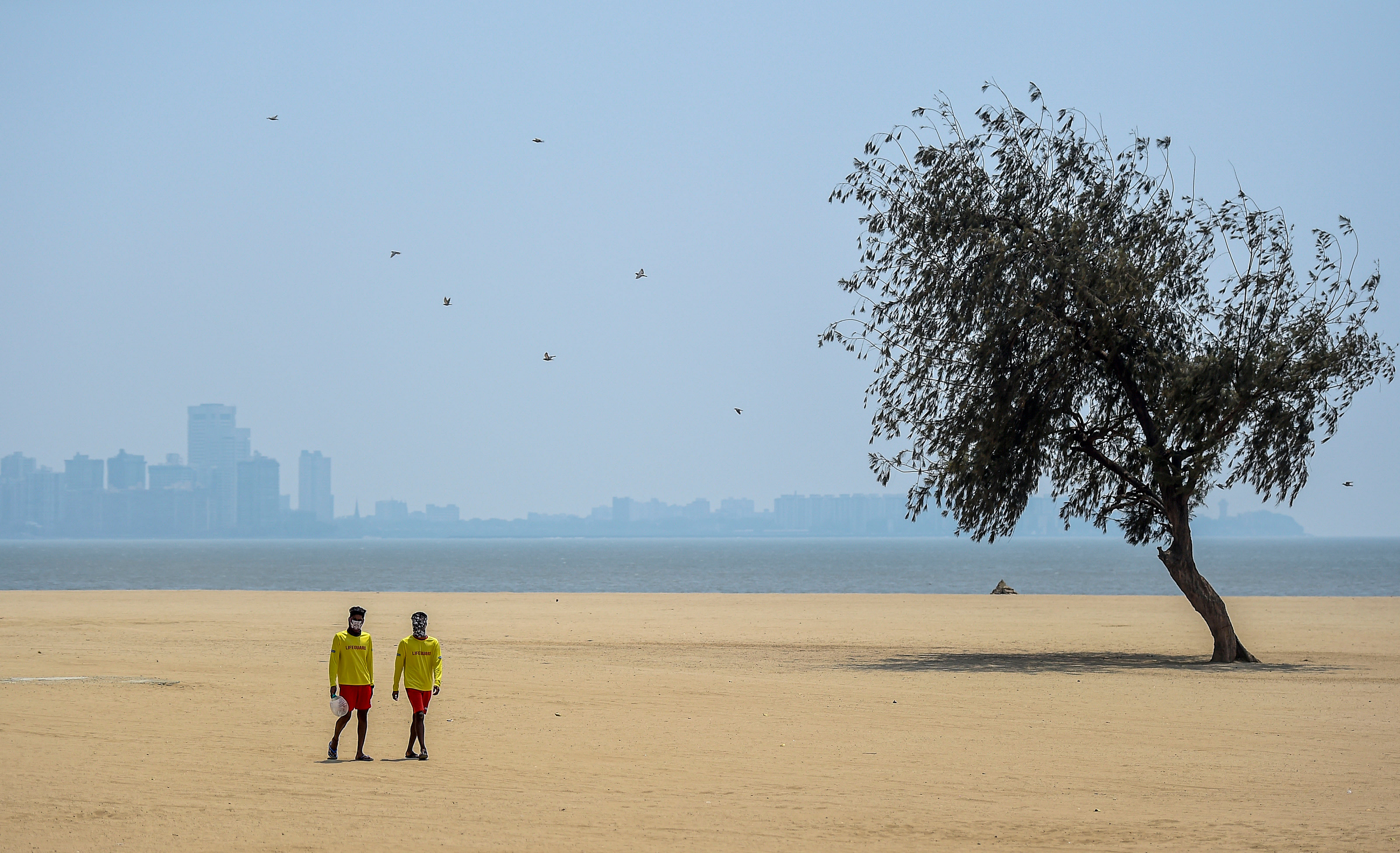 Lifeguards stand at Mumbai's deserted Chowpatty beach amid the lockdown. (Credit: PTI)