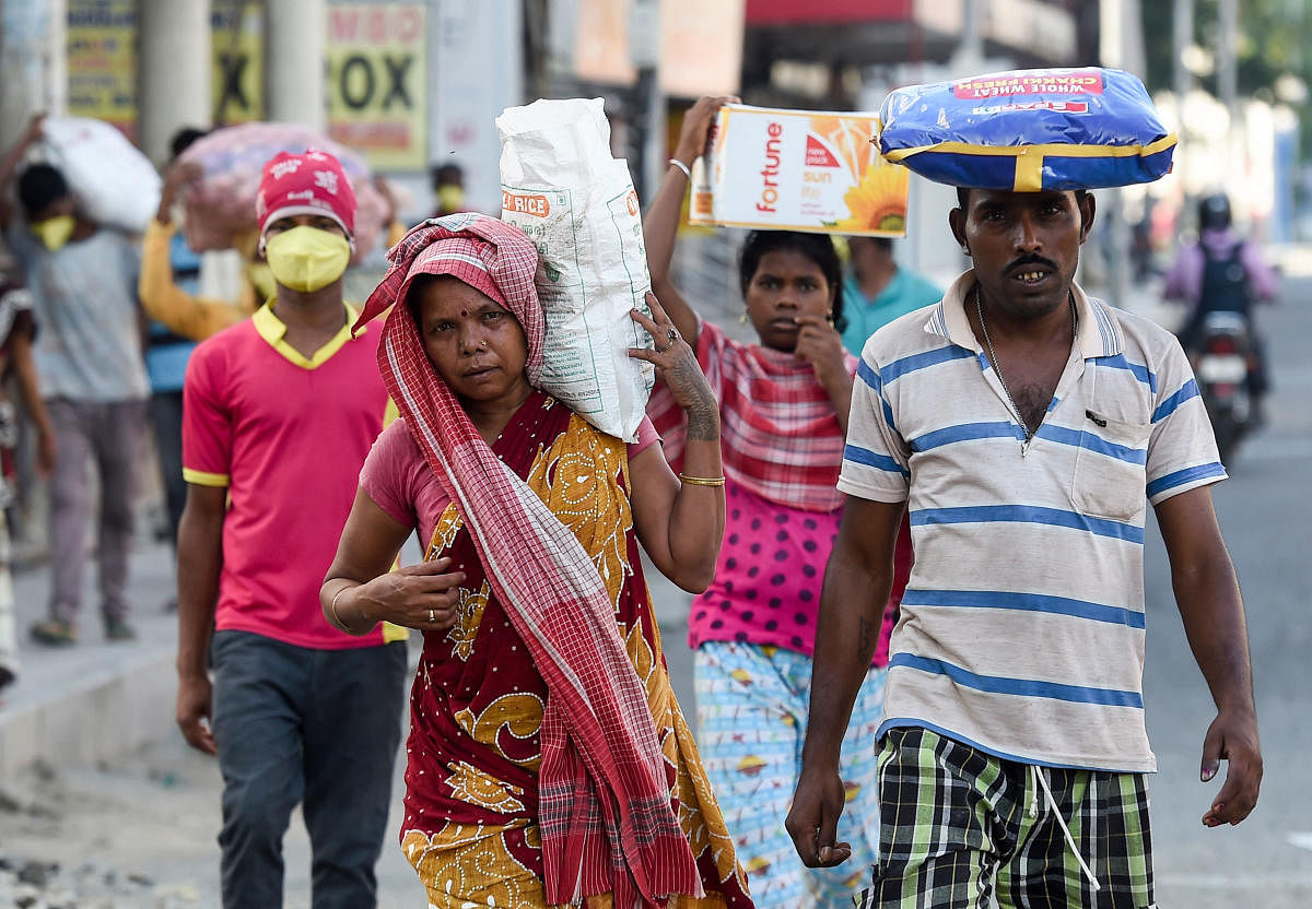 Migrant workers carry sacks of groceries distributed at their workplace during a government-imposed nationwide lockdown as a preventive measure against the coronavirus. PTI