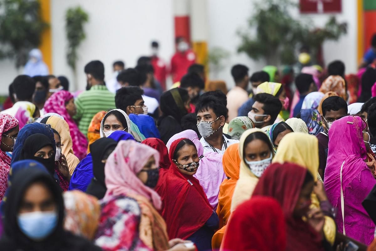 Labourers wait in lines to collect their salary in a garment factory during a government-imposed lockdown in Savar. Representative image/AFP