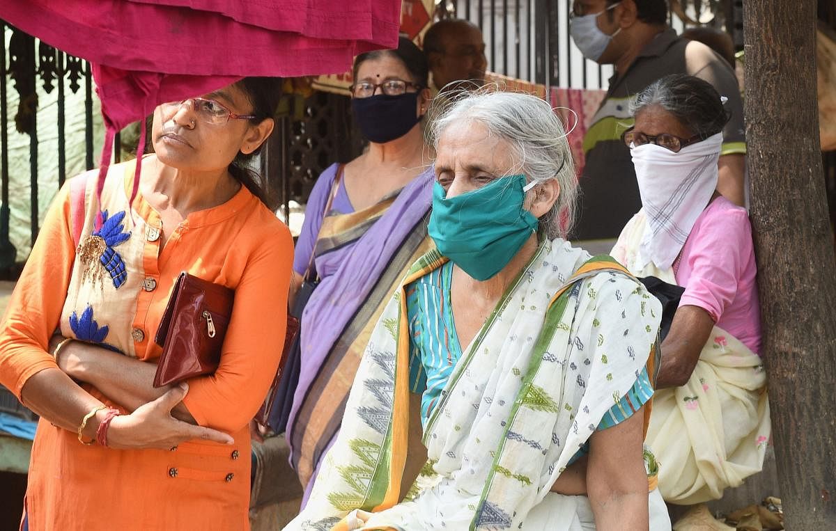 Senior citizens with their family members wait outside a Post office to collect their pension during a nationwide lockdown, imposed in the wake of coronavirus pandemic, in Kolkata, Friday, April 3, 2020. Credit: PTI Photo