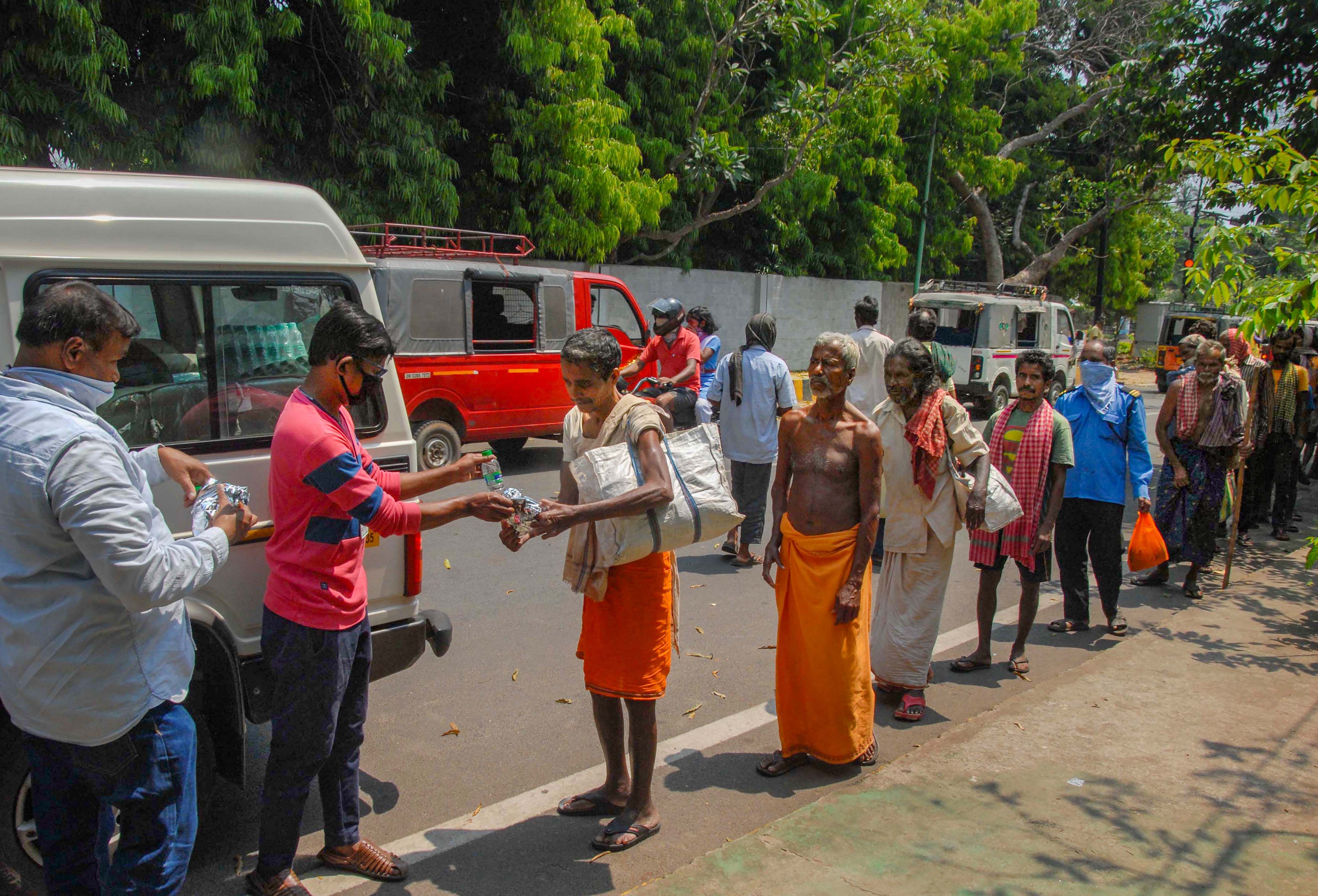 Volunteers distribute food among the needy during a nationwide lockdown in the wake of coronavirus pandemic, in Bhubaneswar. (Credit: PTI Photo)