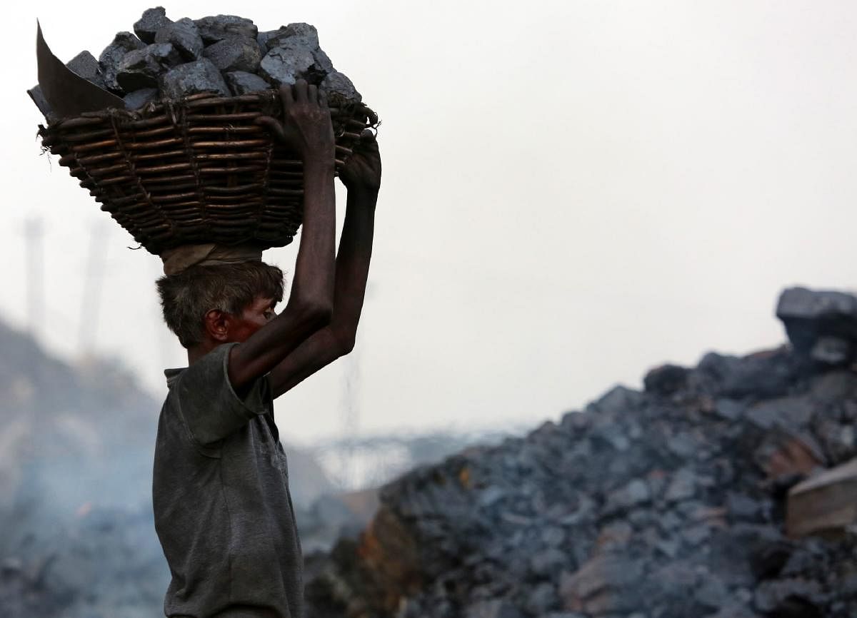  In this file photograph taken on June 27, 2017, an Indian coal scavenger carries a basket of coal collected at a mine in the district of Dhanbad in the state of Jharkhand. Credit: AFP Photo