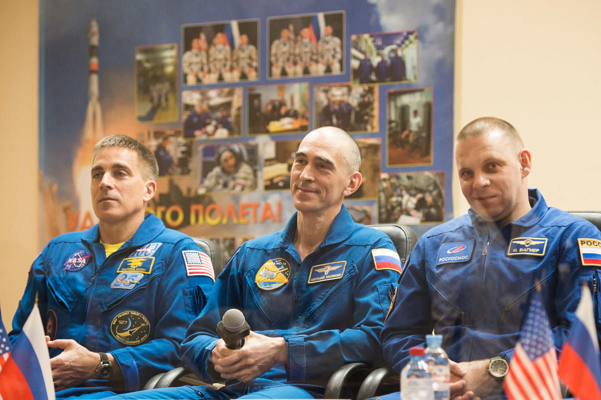 This handout picture taken and released on April 8, 2020 by the Russian space agency Roscosmos shows NASA astronaut Chris Cassidy and Russian cosmonauts Anatoly Ivanishin and Ivan Vagner, members of the International Space Station (ISS) expedition 63, holding a press conference at the Russian-leased Baikonur cosmodrome. Credit: AFP