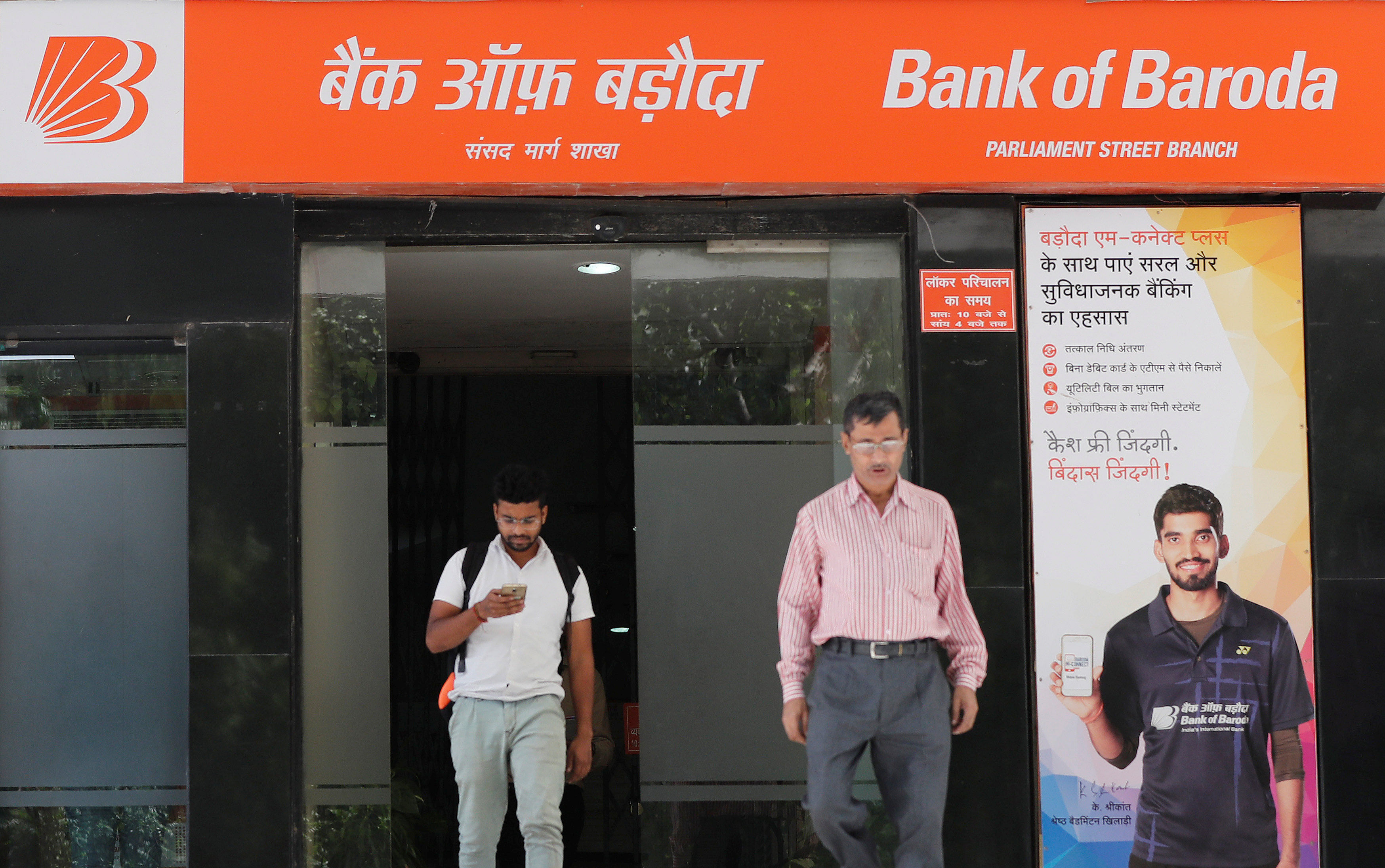 People walk out from Bank of Baroda in New Delhi, India. (Credit: Reuters)