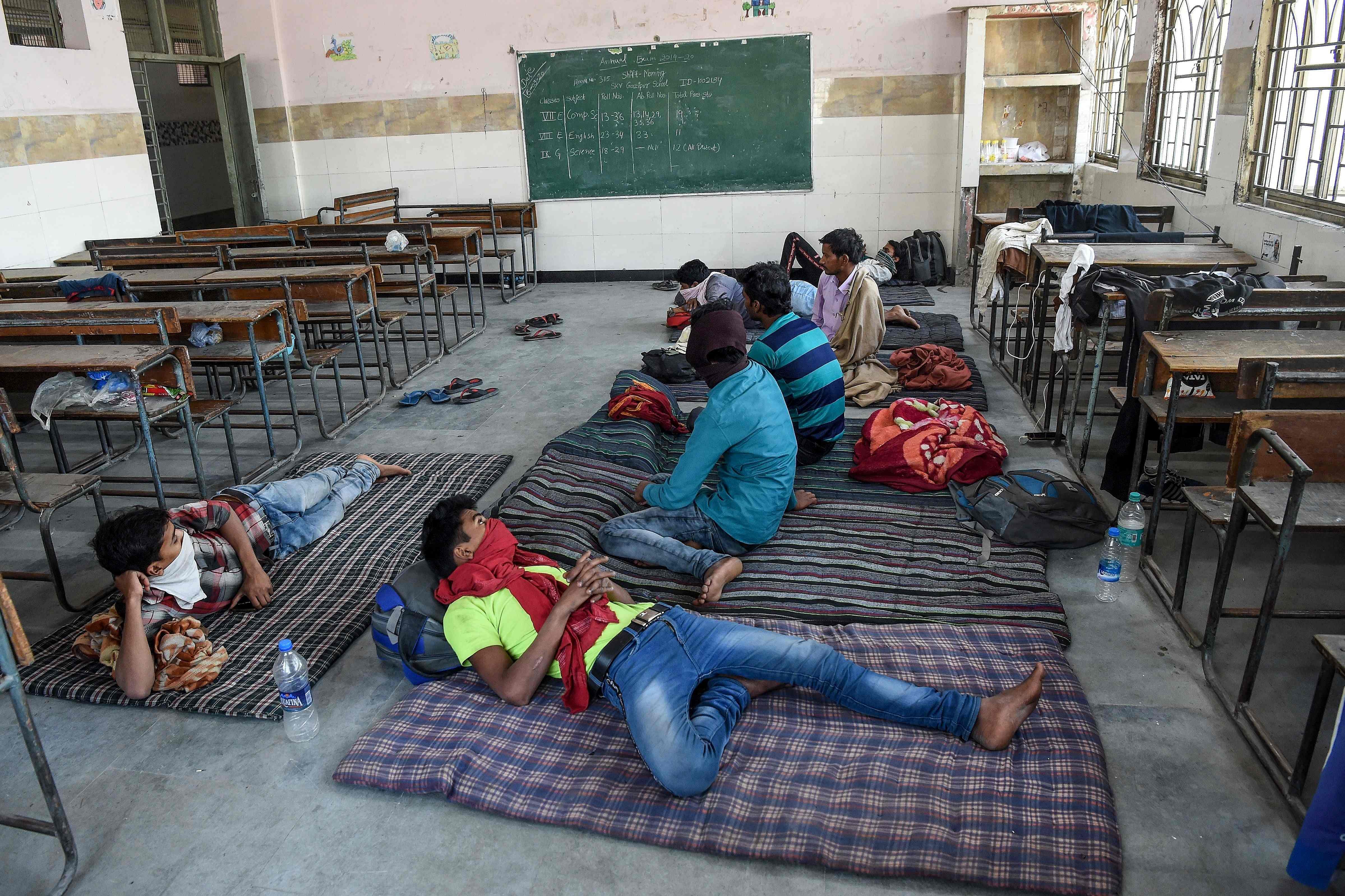 In this file photo taken on April 1, 2020 Migrant workers from Bihar state take a rest at a camp set up by Delhi Government. (Credit: PTI Photo)