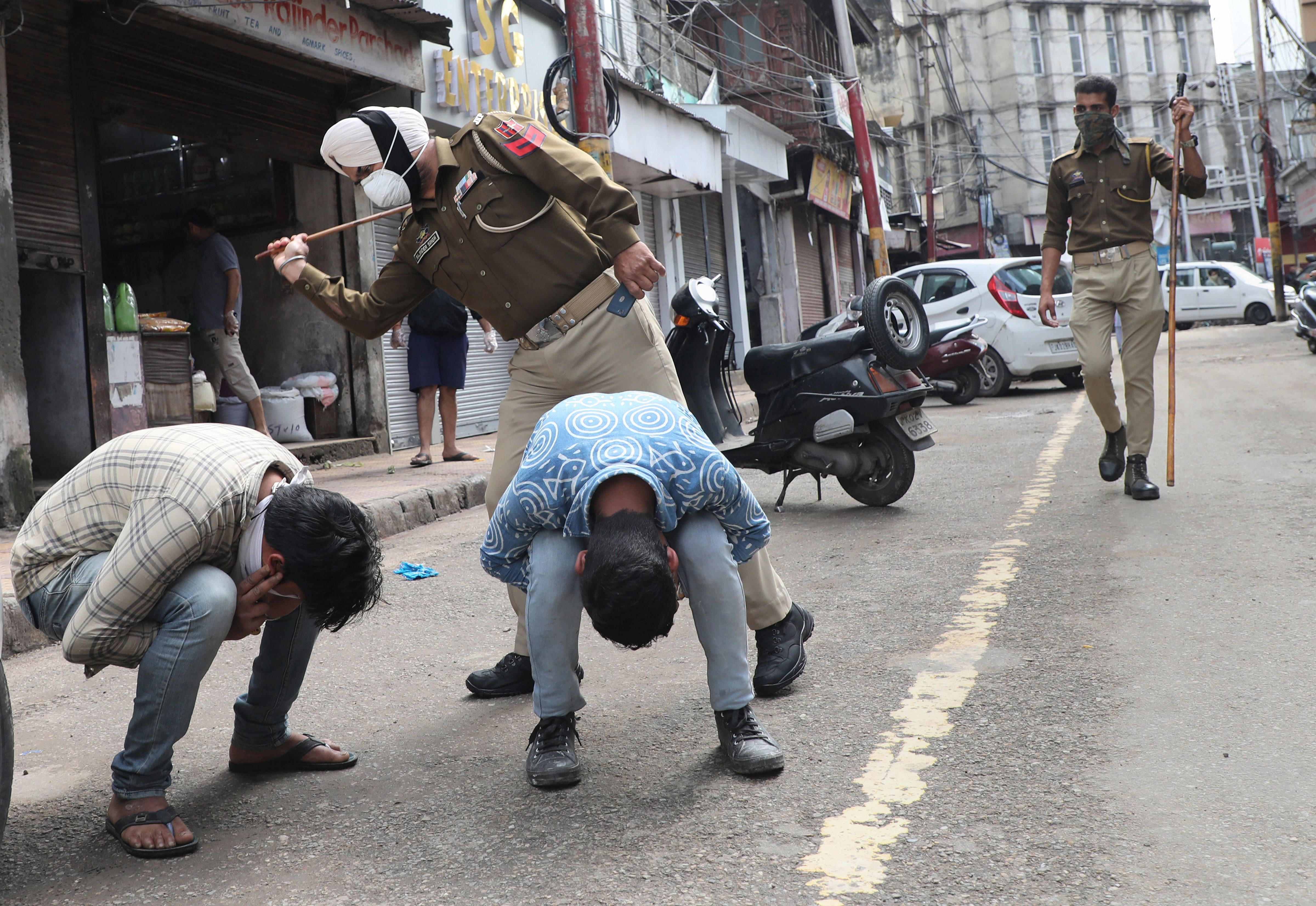 Police personnel punish people for venturing out of their homes during a nationwide lockdown, imposed in the wake of coronavirus pandemic, in Jammu. (PTI Photo)
