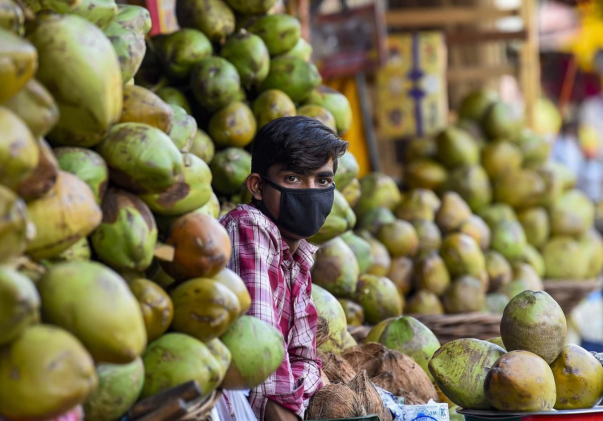 A coconut seller is seen wearing a mask during the nationwide complete lockdown imposed in a bid to contain the coronavirus pandemic, in New Delhi, Friday, April 10, 2020. (PTI Photo)