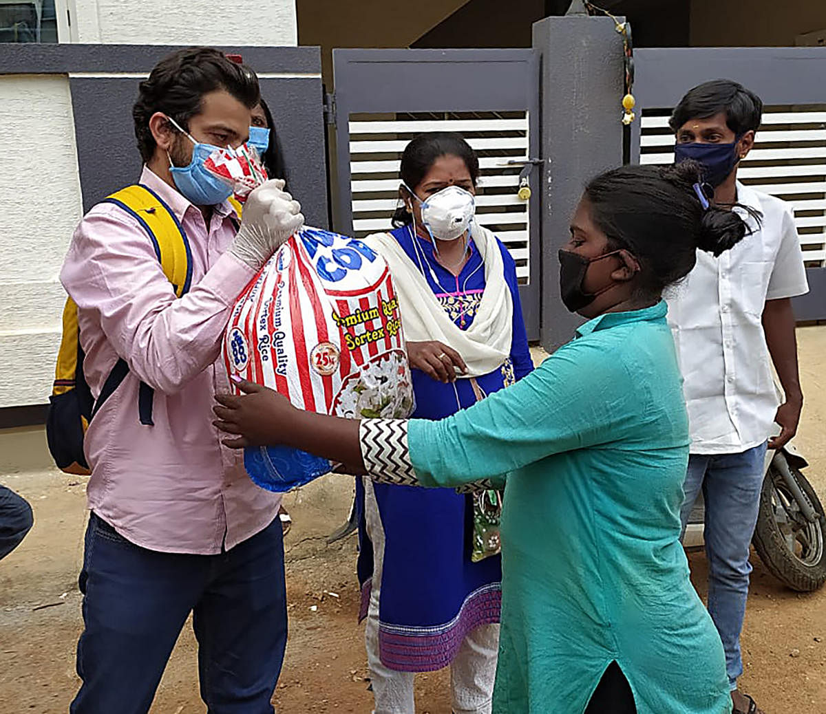 Volunteers of The Satsang Foundation, Bengaluru hand over 14-days provision boxes to migrant workers in Thanisandra in Bengaluru. DH Photo