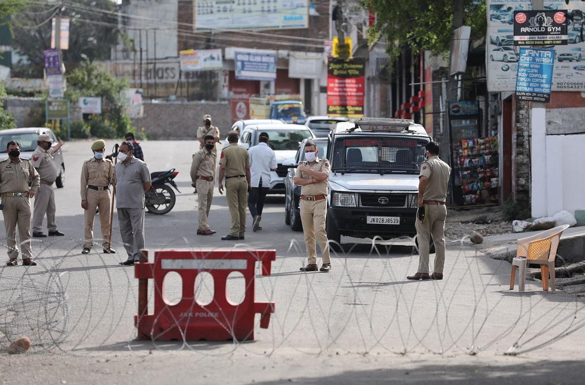 Security personnel stand guard on a deserted road during the nationwide lockdown to curb the spread of coronavirus. PTI