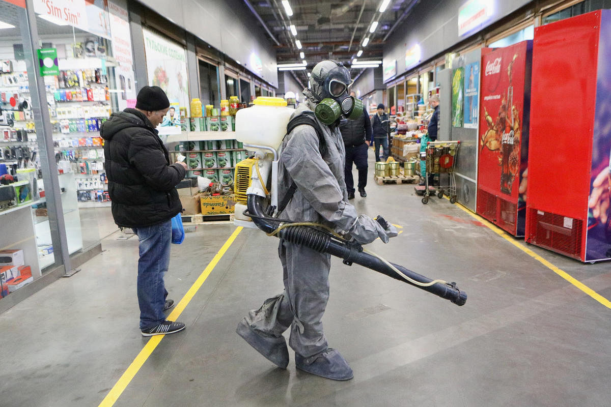  A specialist wearing protective gear sprays disinfectant inside retail market amid COVID-19 outbreak in Moscow (Reuters Photo)