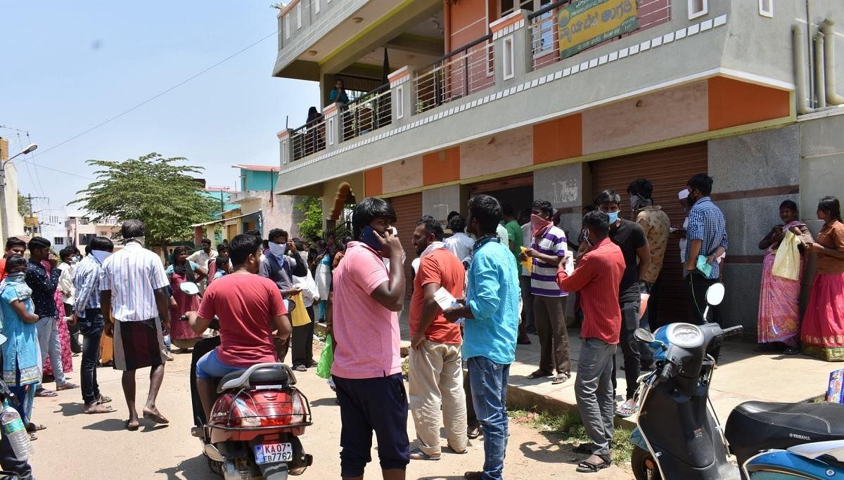 Consumers wait outside a  public distribution system in large number violating social distancing guideline