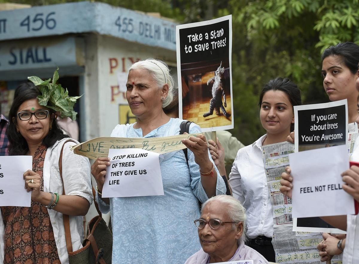 Activists from various environmental organisations display placards during a demonstration to save trees, at Sarojini Nagar area. PTI photo.