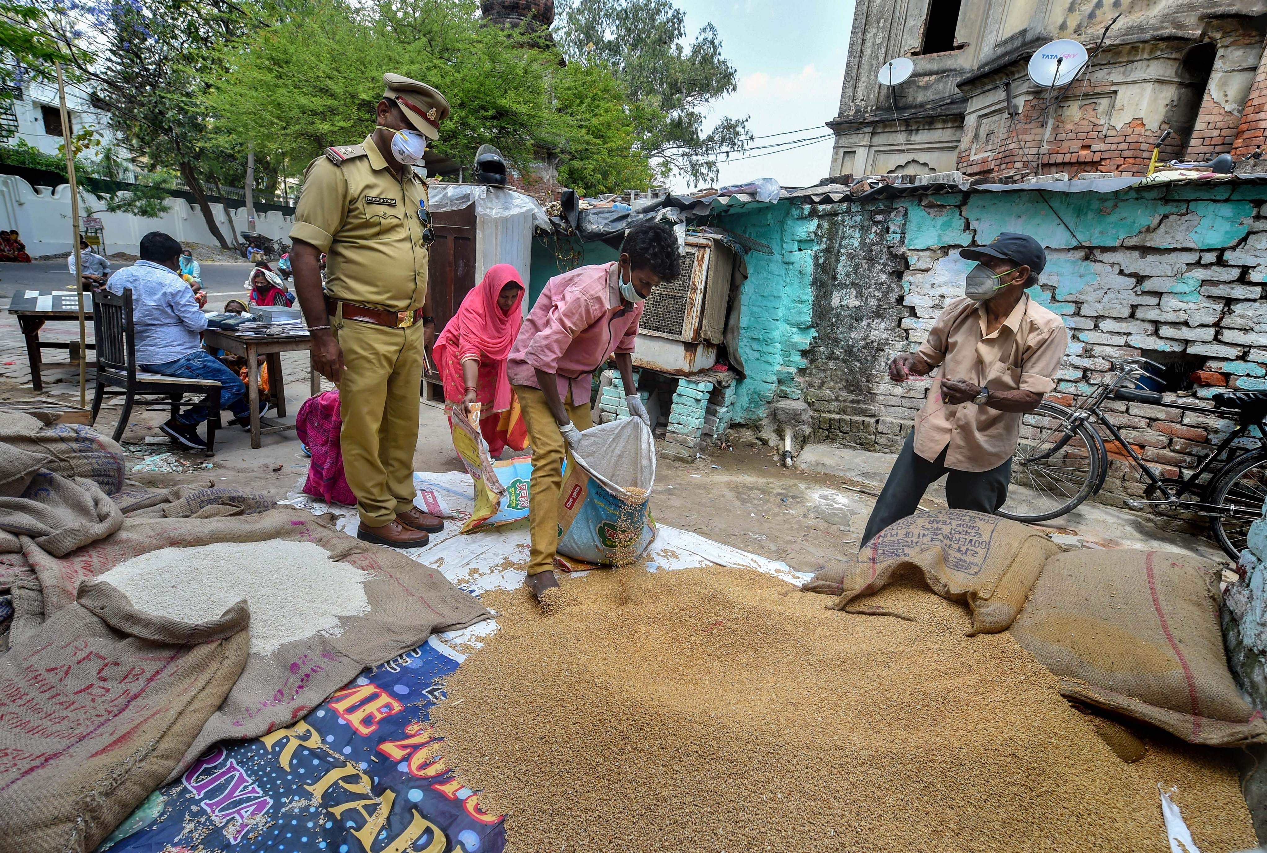 Lucknow: People maintain safe distance while collecting ration from a PDS centre, during the nationwide lockdown. (Credit: PTI)