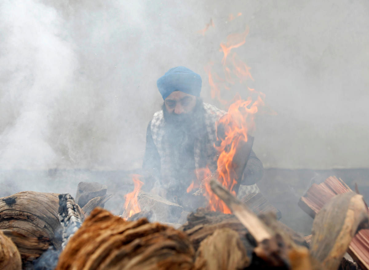 An Afghan Sikh man lights the funeral pyre for the victims who were killed during the attack at Sikh religious complex during a funeral in Kabul, Afghanistan March 26, 2020.REUTERS/Mohammad Ismail