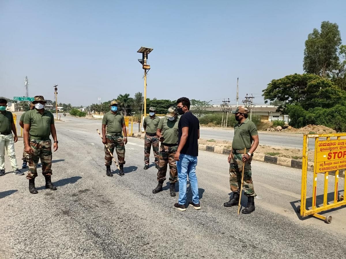 Indian Army personnel help police to enforce lockdown at the district border in Tumakuru on Sunday. DH Photo