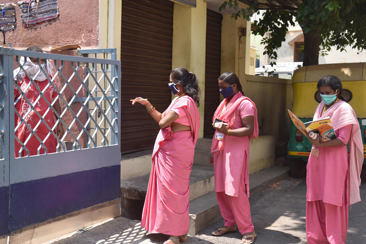 ASHA workers collecting family health details, at Bapuji nagar, BBMP seal off to control coronavirus, implement covid-19 lockdown at Bapuji Nagar ward (ward 134) in Bengaluru on Saturday, 11 April 2020. Credit: DH Photo