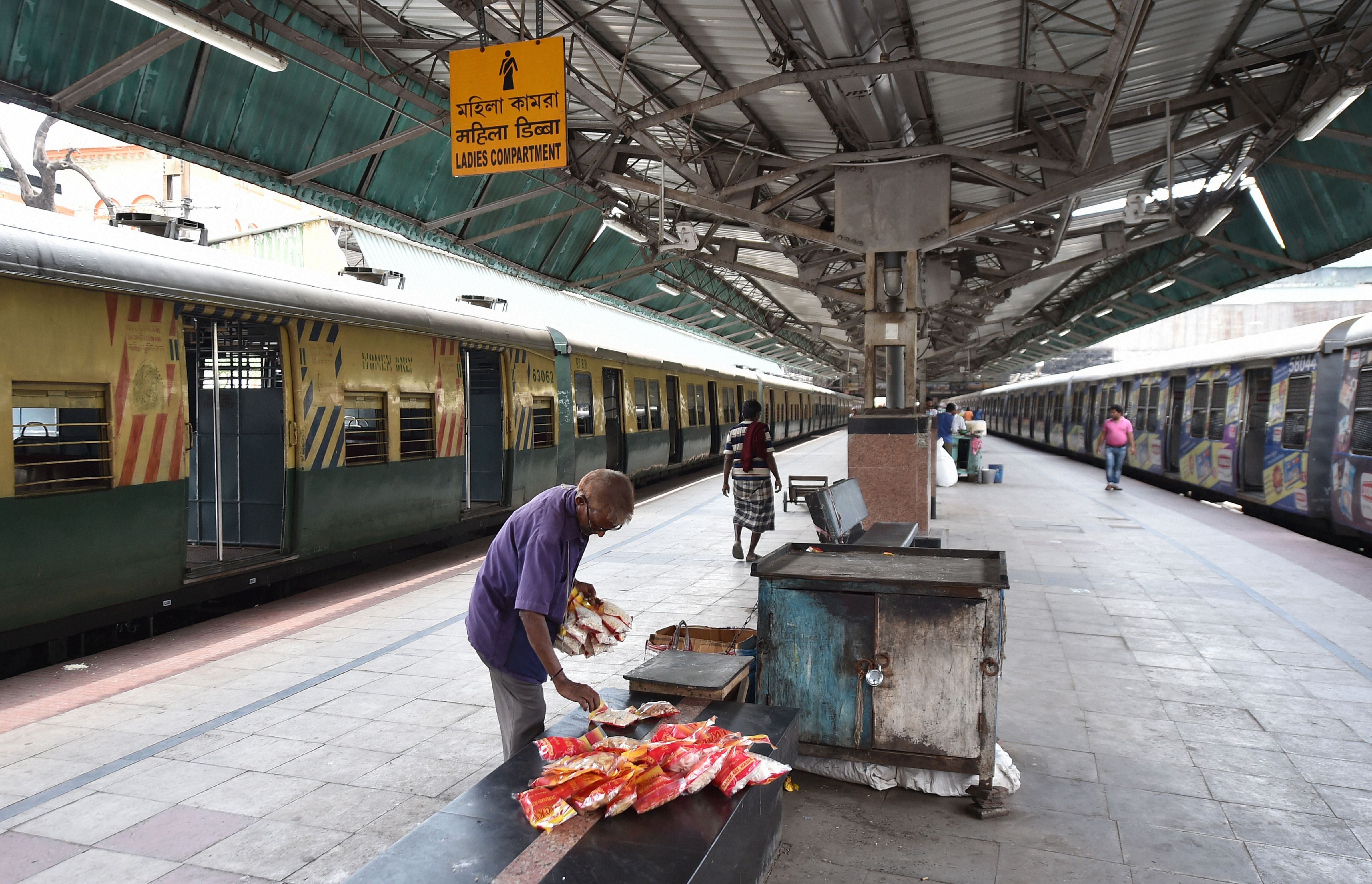 A hawker counts his unsold items at a deserted platform of Sealdah Railway Station, in the wake of coronavirus pandemic in Kolkata. (Credit: PTI)