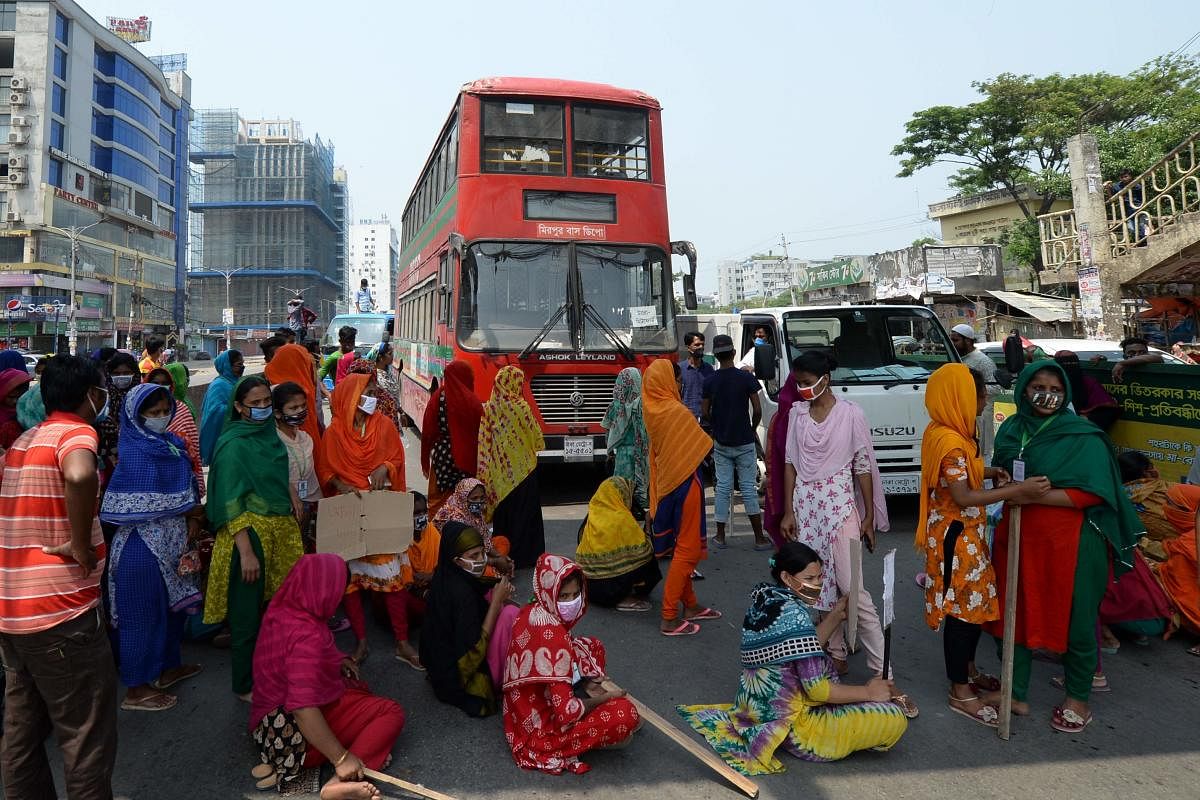 Workers from the garment sector block a road during a protest to demand payment of due wages (AFP Photo)