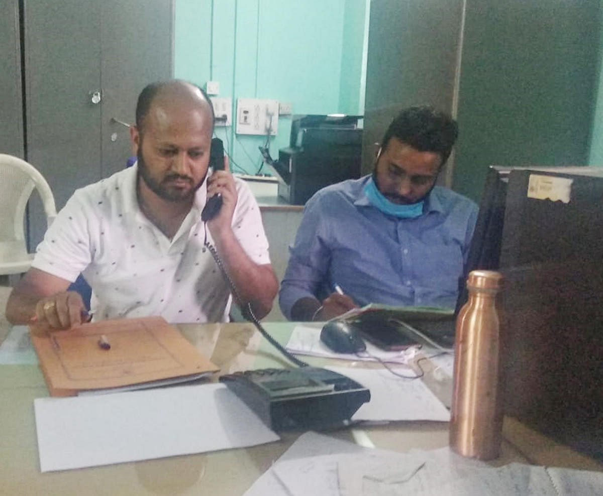 An official attends a phone call at Agri war room in Chikkamagaluru on Monday. DH Photo