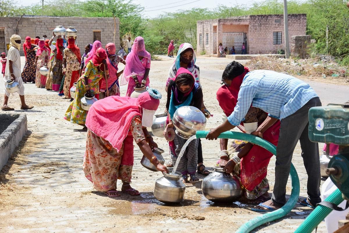 Women stand in a queue to collect potable water from a tanker in a village near Jodhpur. PTI/File