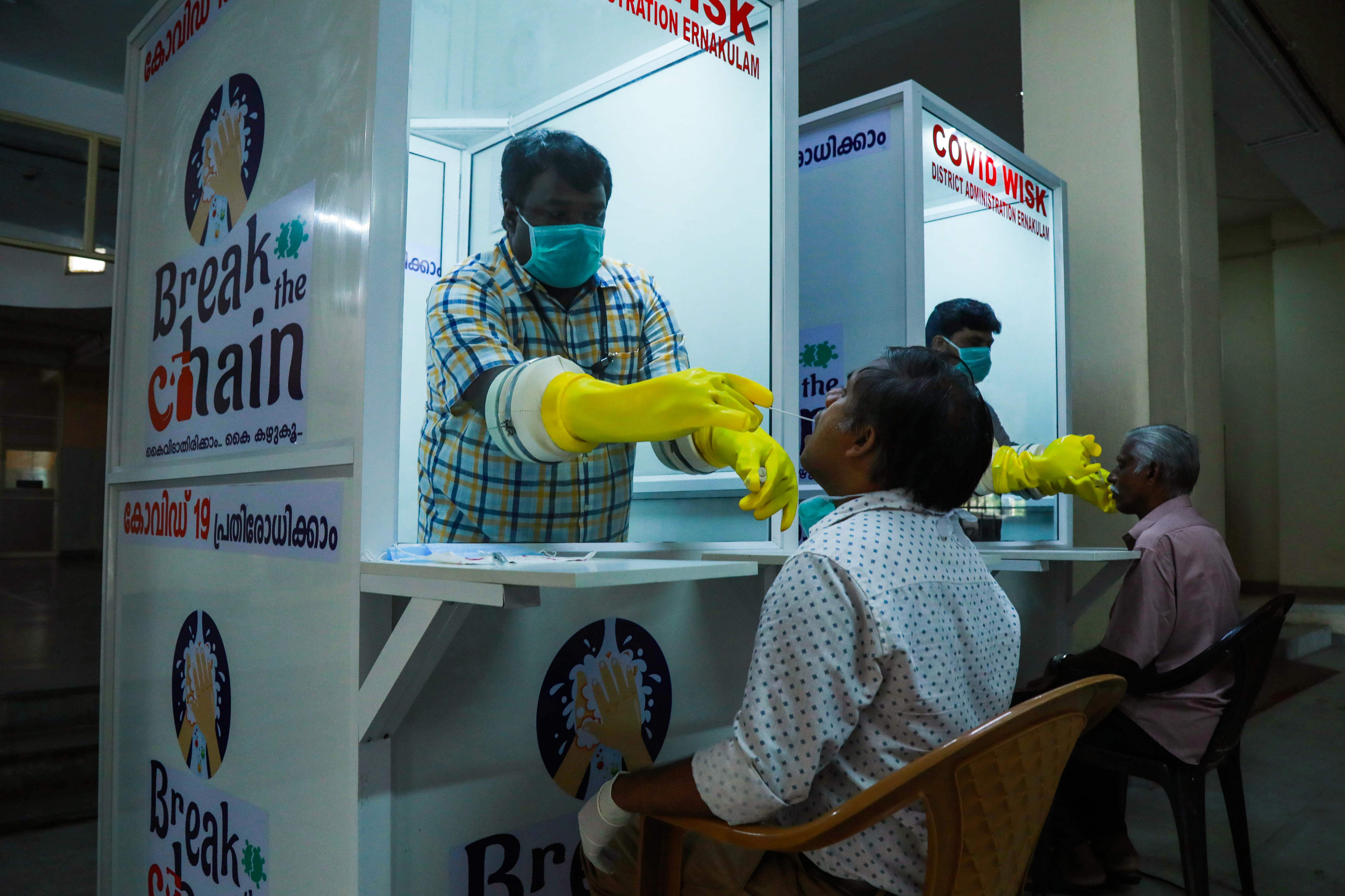 Medical staff collect samples from people at newly set upped Walk-In Sample Kiosk (WISK) to test for the COVID 19 coronavirus at Ernakulam Medical College in Kerala. (Credit: AFP Photo)