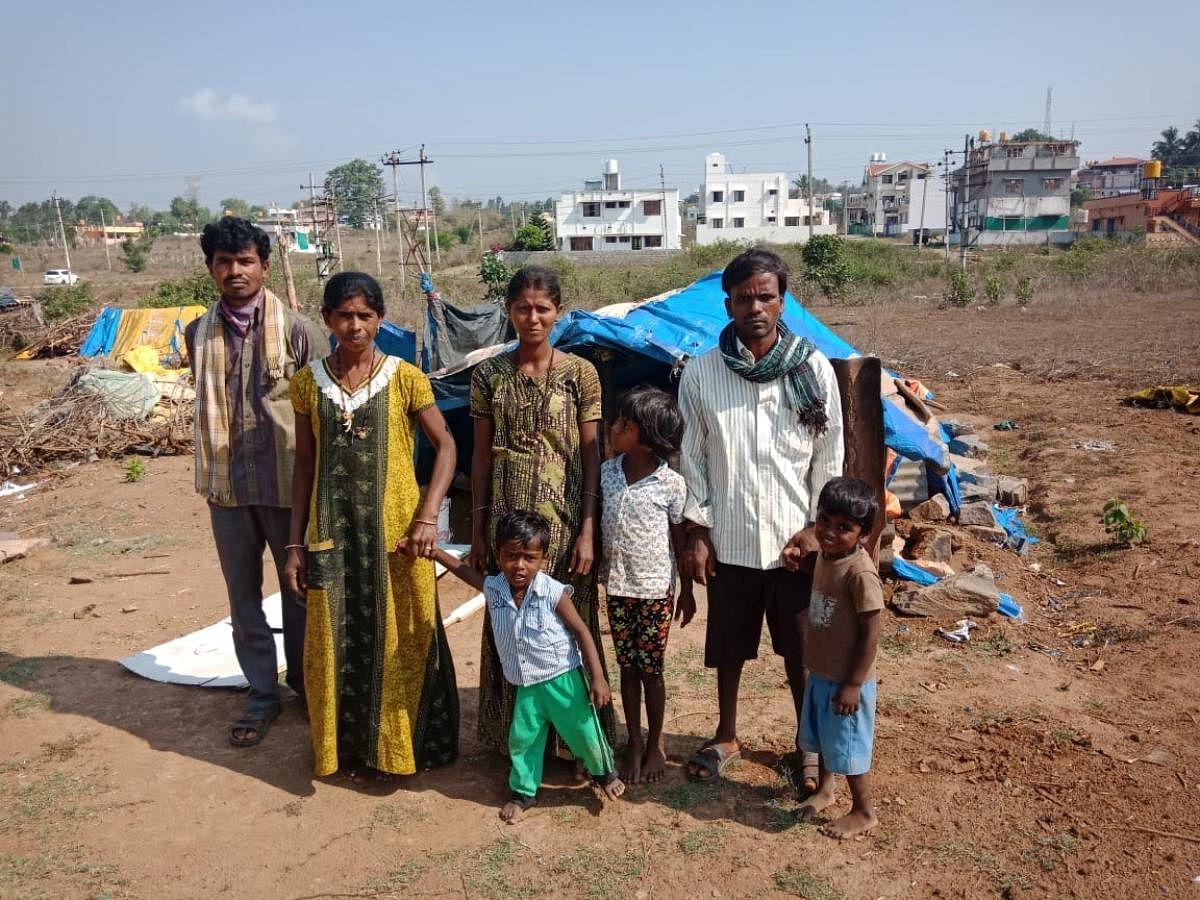 Migrant labourers, dwelling in a vacant site, await assistance in Kushalnagar. DH Photo  